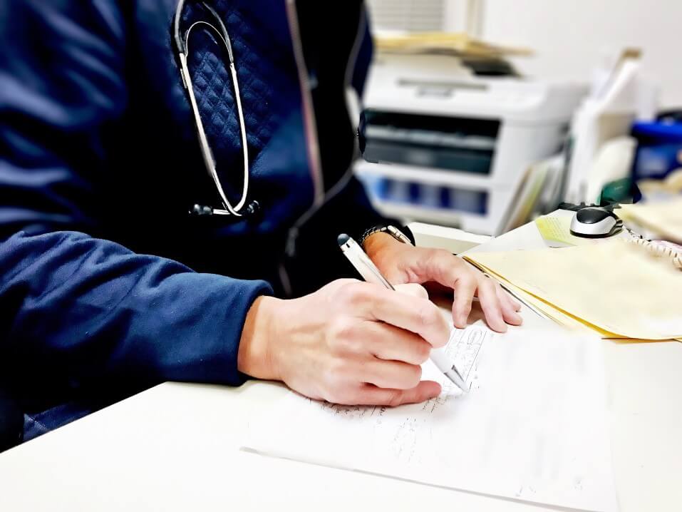 doctor-wearing-stethescope-around-his-neck-writing-patients-notes-during-consultation-real-life_t20_9lp4Oy (1)